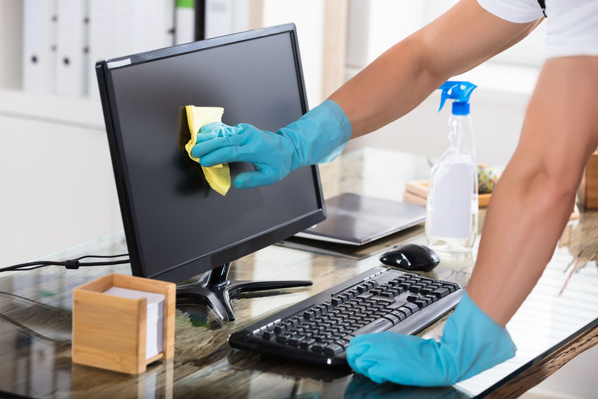 Close-up Of A Janitor's Hand Wearing Gloves Cleaning Computer Screen With Rag